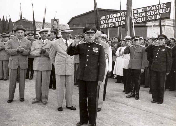 Mareşalul K.E. Vorosilov răspunzând ovaţiilor entuziaste ale mulţimii venită pe aeroportul Băneasa pentru a saluta plecarea delegaţiei guvernamentale sovietice, care a vizitat ţara noastră cu prilejul sărbătoririi zilei de 23 august 1951. Se aflau de faţă: Gheorghe Gheorghiu –Dej, Petru Groza, Chivu Stoica, Kavtaradze S.I., ş.a.        (25.08.1951).